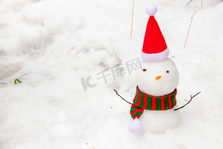拿拖把的雪人摄影照片_下雪天白天雪人室外玩雪摄影图配图