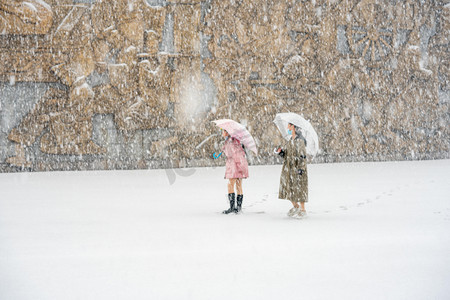 小寒女孩摄影照片_下雪天白天雪地上的女孩广场玩耍摄影图配图