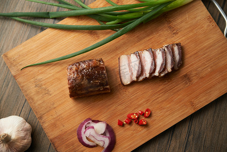 美食腊肉摄影照片_食物冬季节日腊肉餐桌砧板切片摄影图配图