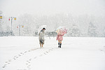 下雪天白天雪地上的小女孩野外雪地上行走摄影图配图