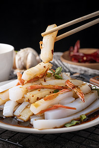 中国风粉摄影照片_凉菜食物凉粉木桌夹起摄影图配图