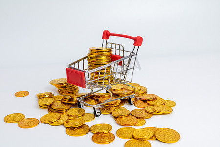 消费棚拍购物车里的金币消费概念静物摄影图配图