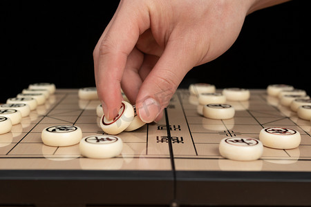 中国象棋室内下棋的手棚拍静物摄影图配图