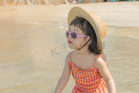孩子旅游摄影照片_小女孩沙滩玩水摄影图配图