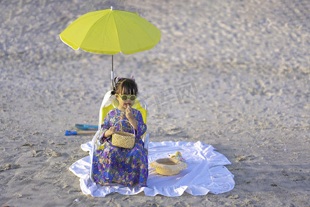 沙滩夏日旅游摄影照片_海边女孩夕阳女孩沙滩晒太阳摄影图配图