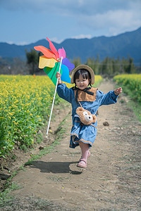 农村春天女孩油菜花地奔跑摄影图配图