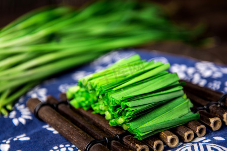 冰女青花瓷摄影照片_美食白天切好的韭菜青花布上摆放摄影图配图