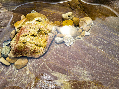 水中鹅卵石摄影照片_鹅卵石中午水中石头大自然摄影图配图