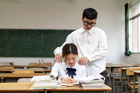青春男女情侣大学生在校园教室里学习