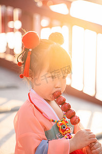 汉服小女孩夕阳女童庙会吃糖葫芦摄影图配图