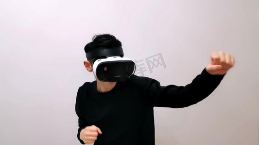 竞电游戏摄影照片_年轻男子玩VR格斗游戏