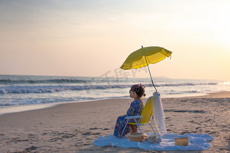 海边野餐的小女孩夕阳女孩沙滩看日落摄影图配图