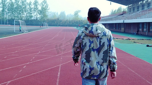 人物行走背影摄影照片_大学校园操场走路背影