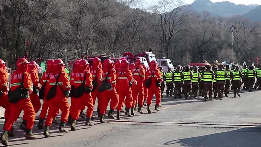 消防急救包摄影照片_全地形消防机器人和整齐的消防员队伍走过