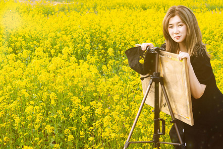 油菜花少女白天少女采风田间画画摄影图配图