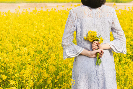 油菜花白天油菜花少女户外田间少女赏花摄影图配图