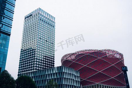 城市仰拍摄影照片_武汉城市建筑阴天建筑群地标万达汉秀剧场仰拍摄影图配图