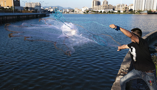撒网捕鱼的人下午撒网城市撒网摄影图配图
