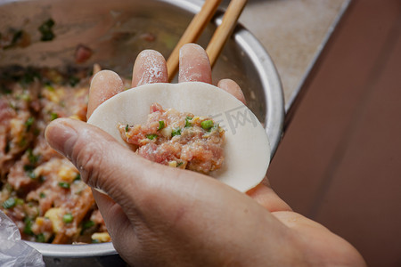 传统美食摄影照片_白天室内传统美食手工制作饺子摄影图配图