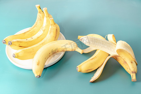 水果生鲜光照下若干香蕉室内纯色背景静物摆拍摄影图配图