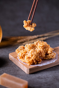 餐饮美食夜晚小酥肉鸡米花室内桌面用筷子夹起摄影图配图