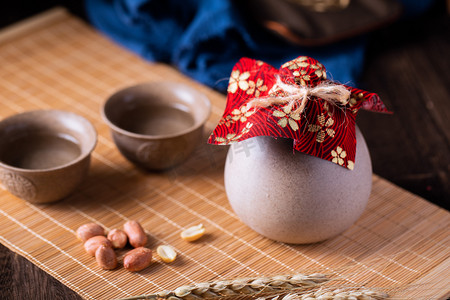 倒白酒摄影照片_白酒夜晚古风酒壶酒杯室内桌面摆拍摄影图配图