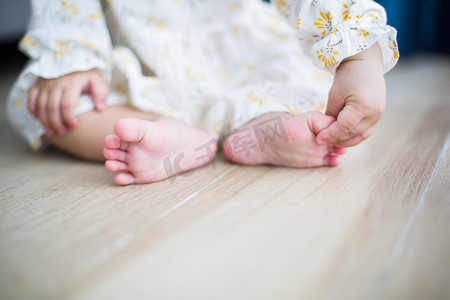宝宝尿垫摄影照片_小宝宝白天宝宝地板上握着脚丫摄影图配图