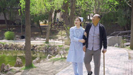 重阳节人物摄影照片_美女护士陪护老年人公园散步锻炼人像