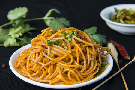 面食摄影照片_特色小吃白天面食热干面室内摆拍摄影图配图