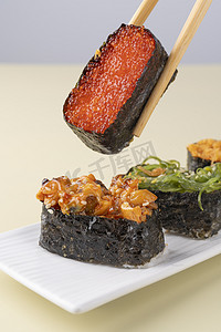 美食摄影照片_寿司小吃美食鱼子夹起摄影图配图