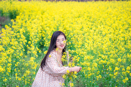 观赏摄影照片_油菜花人像春季白天美女户外观赏摄影图配图