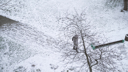 国外寒冬季节女生在雪地里漫步行走