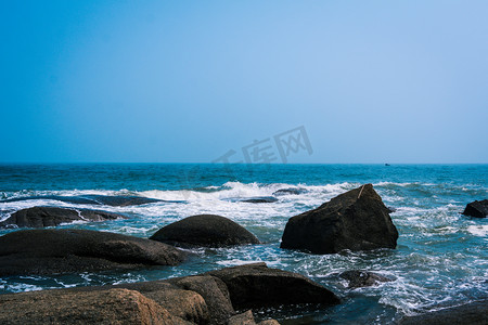 阳光沙滩摄影照片_礁石春天沿海大海拍打摄影图配图
