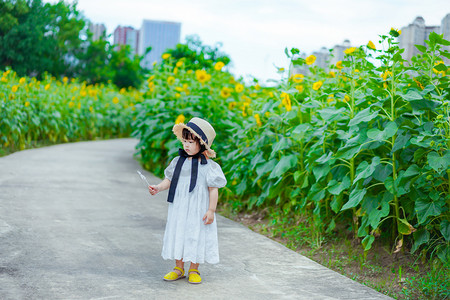 sunflower摄影照片_儿童孩子向日葵花海傍晚女童户外正面摄影图配图