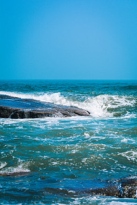 游玩摄影照片_游玩夕阳海洋岩石击打摄影图配图