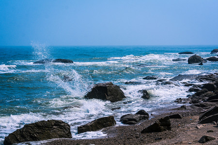 夏日海边沙滩玩耍摄影照片_海滩中午海边大海玩耍摄影图配图