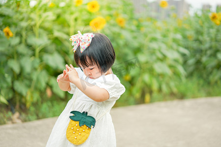 sunflower摄影照片_儿童孩子花海女童傍晚女童向日葵侧面摄影图配图