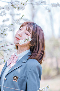 清新宣传摄影照片_文艺人像白天JK制服少女樱花树下抬头闭眼闻花香摄影图配图美女