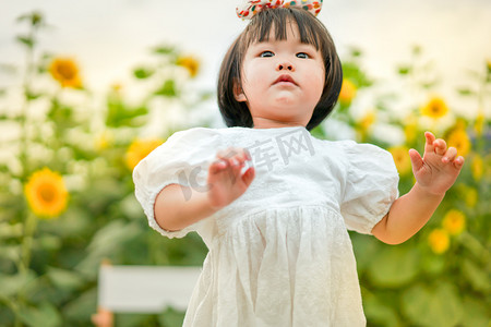 人物半身图摄影照片_儿童孩子女童花海下午女孩2岁向日葵地仰拍半身摄影图配图