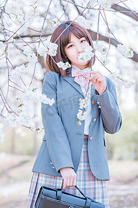 日系摄影照片_文艺日系人像白天JK制服少女樱花树下用花挡脸摄影图配图美女