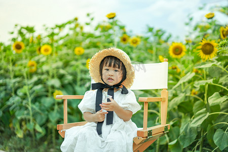 sunflower摄影照片_儿童孩子草帽女孩下午女孩姑娘儿童向日葵正面半身摄影图配图