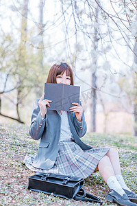 文艺日系人像美女JK制服少女樱花树下用书挡脸摄影图配图