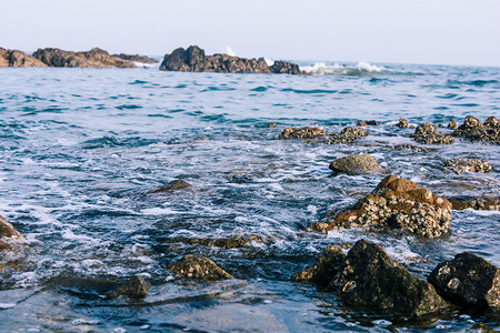 大海礁石摄影照片_度假清晨礁石大海静谧摄影图配图