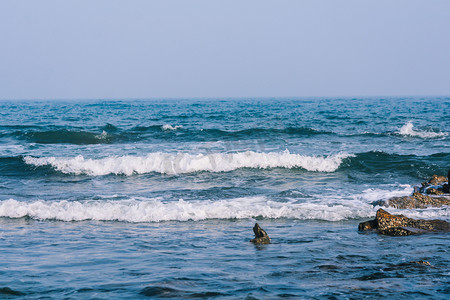 阳光沙滩摄影照片_休闲上午浪花海浪拍打摄影图配图