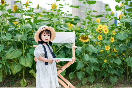sunflower摄影照片_儿童孩子向日葵女孩下午女孩花海向日葵正面摄影图配图