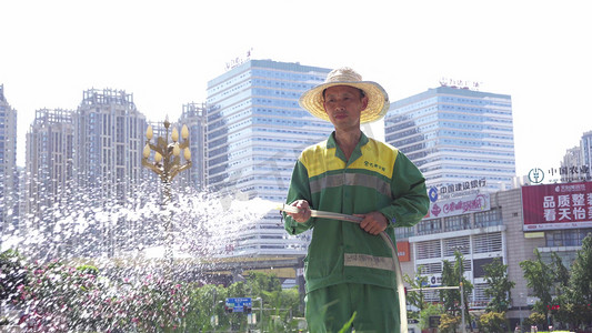 实拍城市高楼街道工人烈日浇水