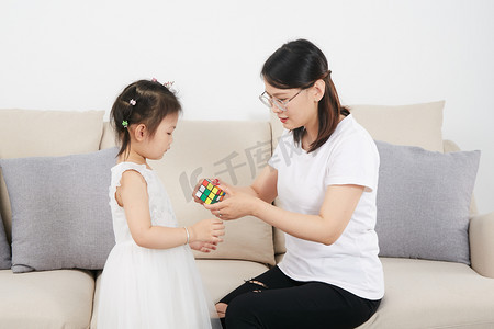 儿童节摄影照片_儿童儿童节妈在家带孩子玩魔方摄影图配图