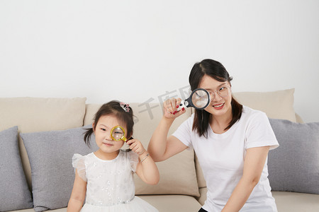 广西故事摄影照片_儿童儿童节女孩和妈妈在家玩耍摄影图配图