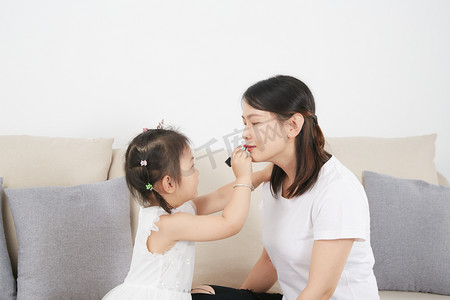 人像口红摄影照片_儿童儿童节女孩给妈妈涂口红摄影图配图