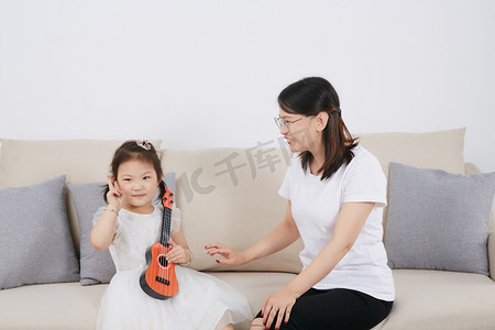 儿童儿童节女孩在家和妈妈玩乐器摄影图配图
